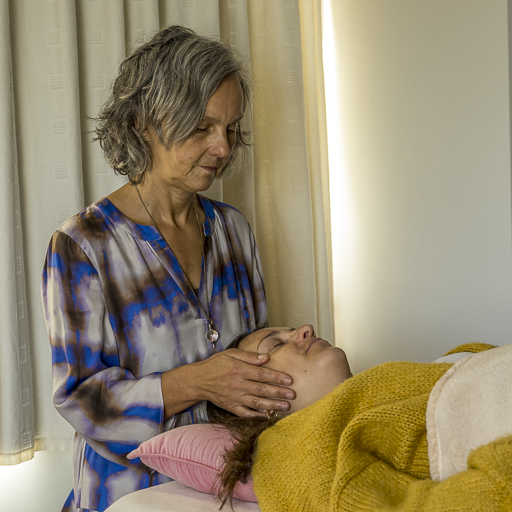 Handen die zachte Reiki-energie doorgeven tijdens een sessie